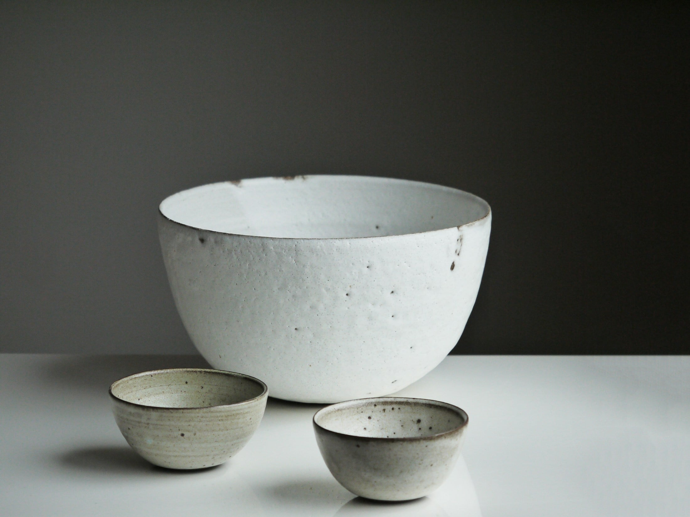 Trois coupes en céramique blanche et grise.